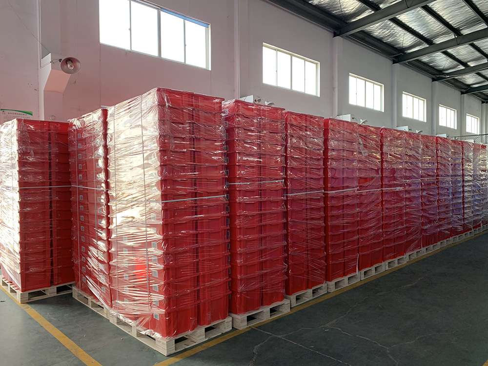 Nested red plastic moving boxes in warehouse.
